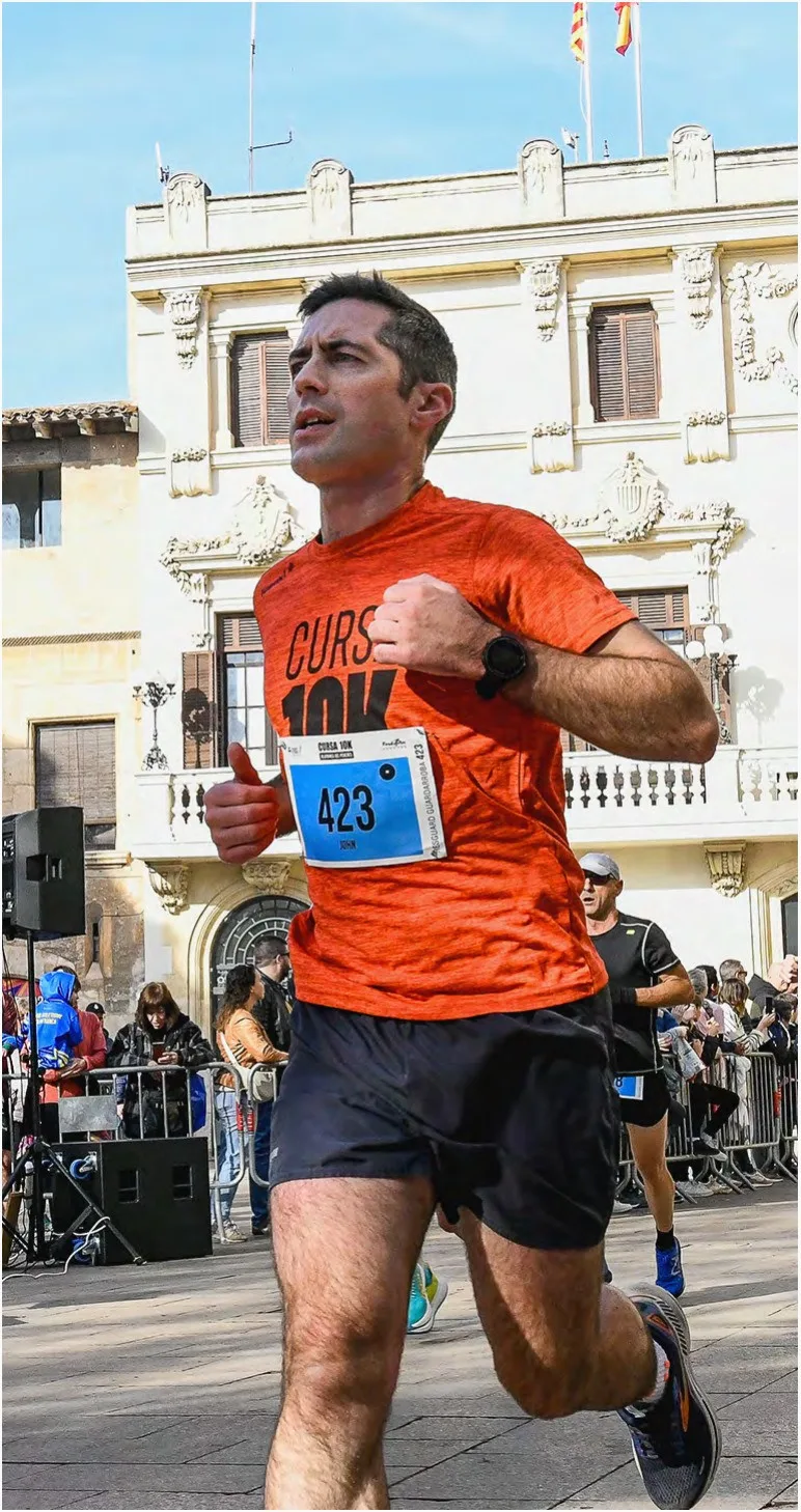 Runner in the orange race T-shirt with bib 423 in front of the town hall