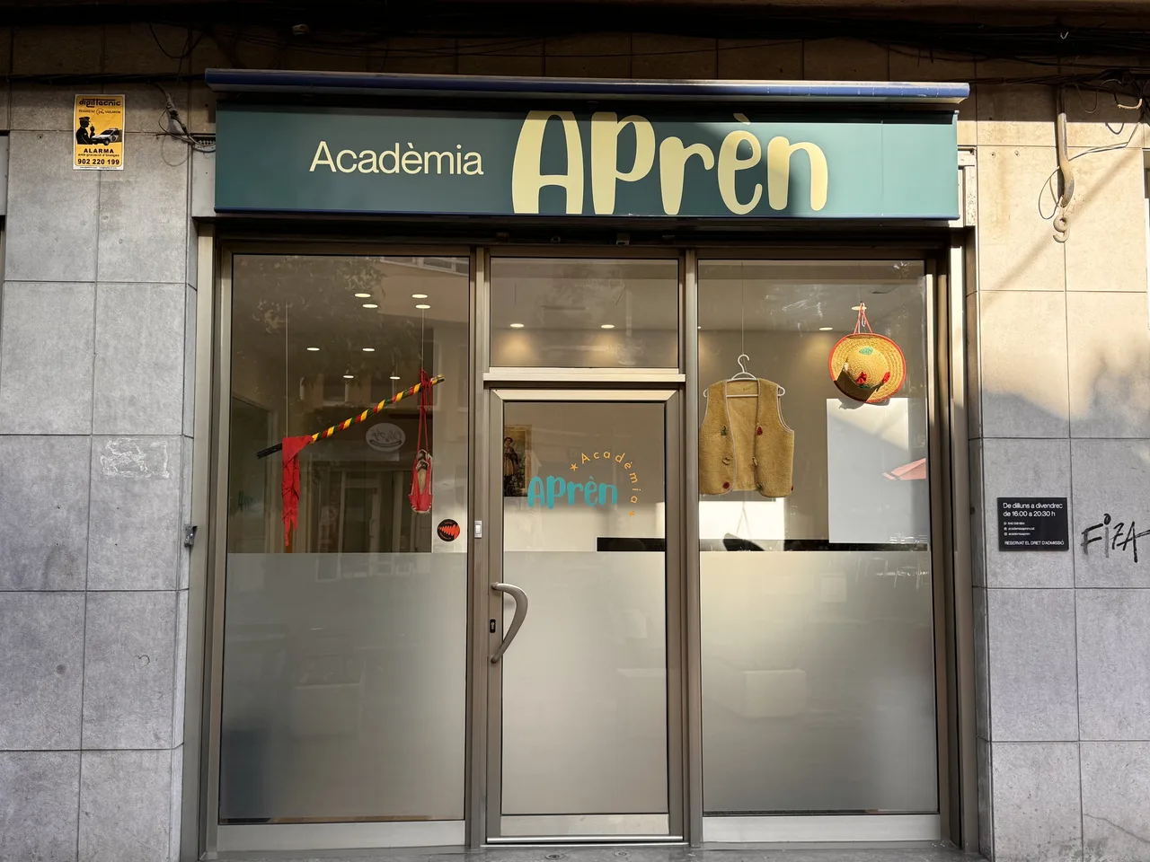 Identitat i web per a una acadèmia de repàs: façana de l'Acadèmia Aprèn amb el rètol nou i els vinils esmerilats als vidres