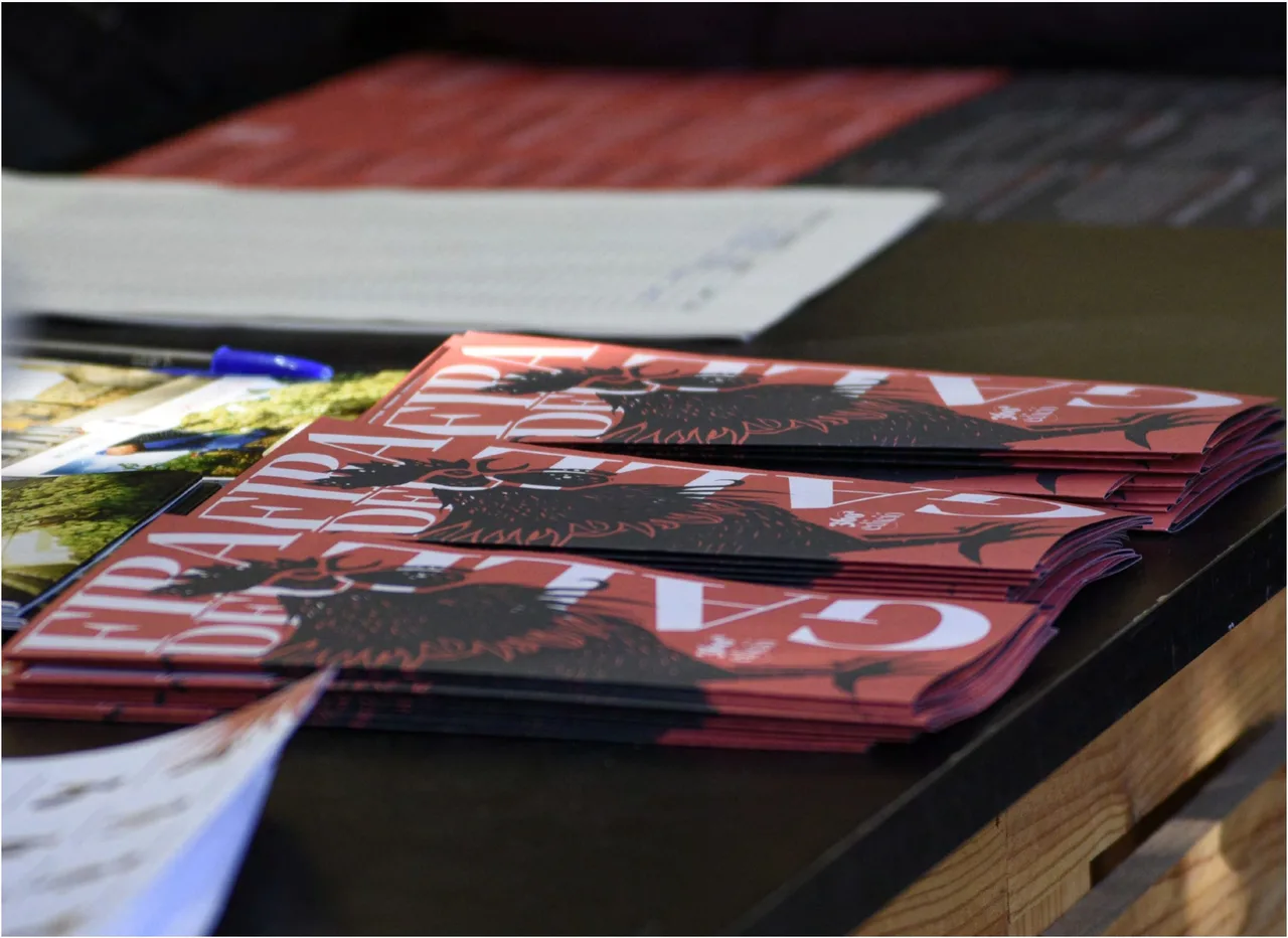 Stack of Fira del Gall programmes with the heraldic rooster illustration in red and black