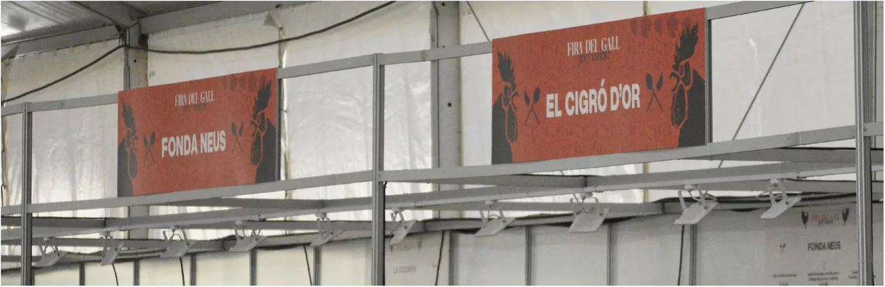 Stall signage for the fair, "Fonda Neus" and "El Cigró d'Or", inside a marquee
