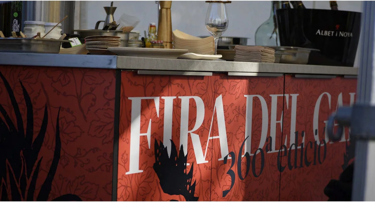 Traditional fair rebranding for Fira del Gall 2024: kitchen counter with the 360th edition logo on a red background with a rooster illustration
