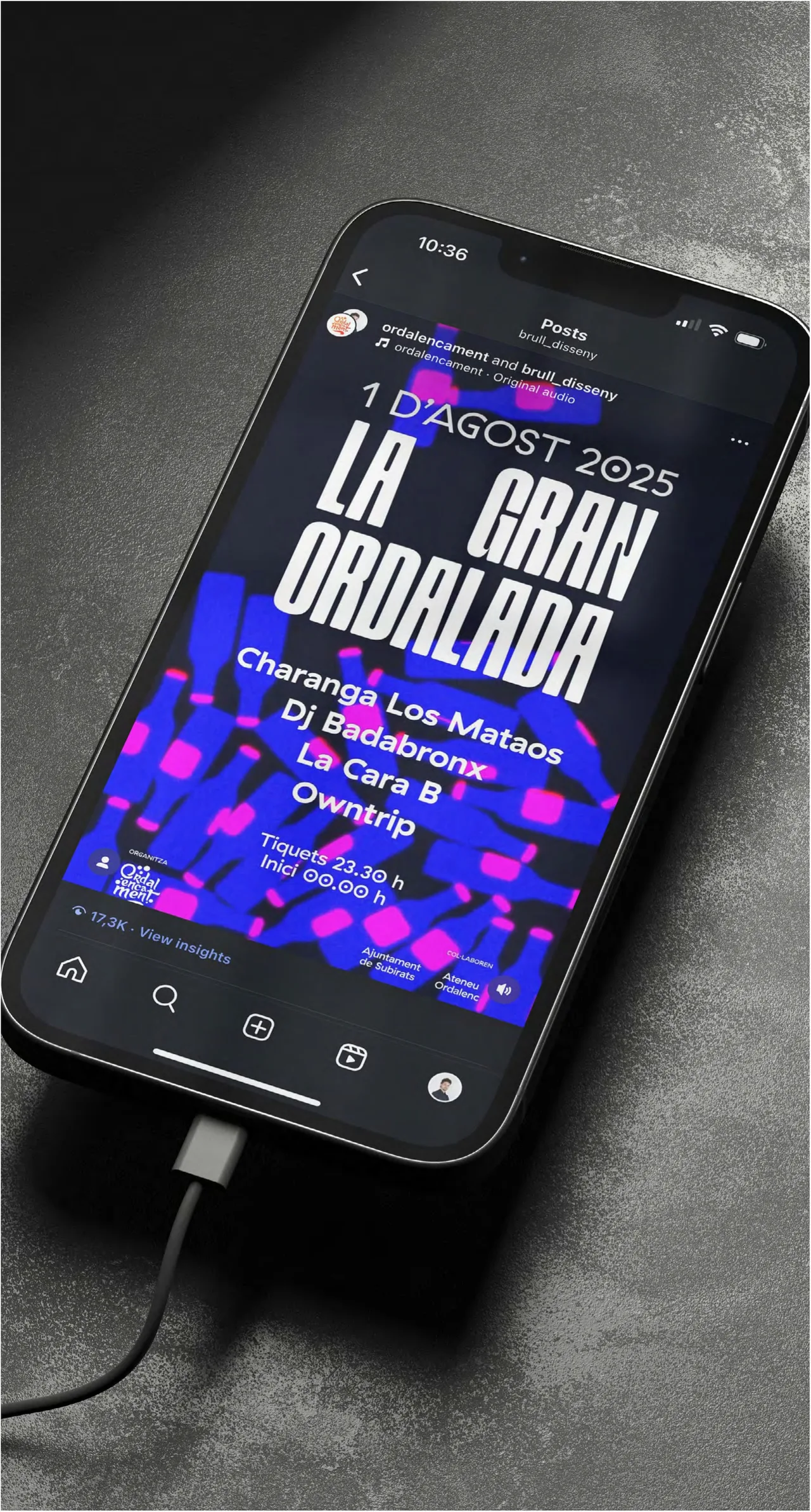 Mòbil sobre una superfície fosca amb el cartell de La Gran Ordalada 2025 i la pluja de quintos