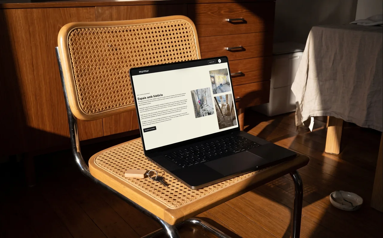 Laptop on a rattan chair showing the history section of the Murmur website