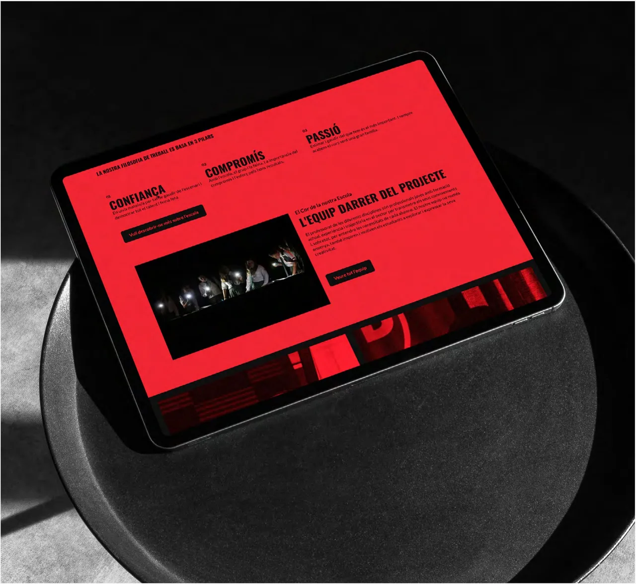 Theater school website: tablet on a stool showing the Artèria website in red and black